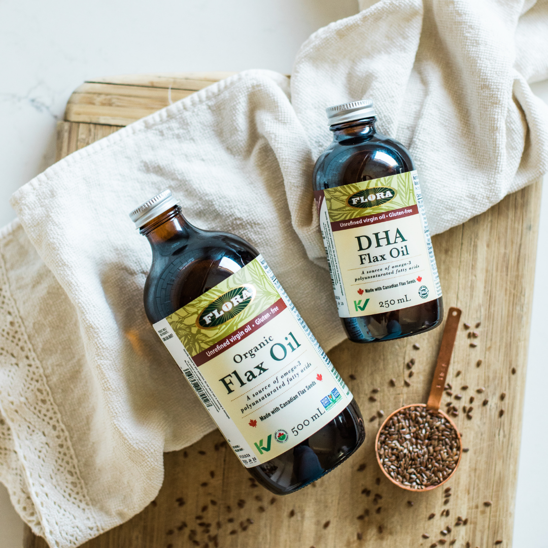 organic flaxseed oil bottle by DHA flax oil bottle on towel with quarter cup of flaxseeds