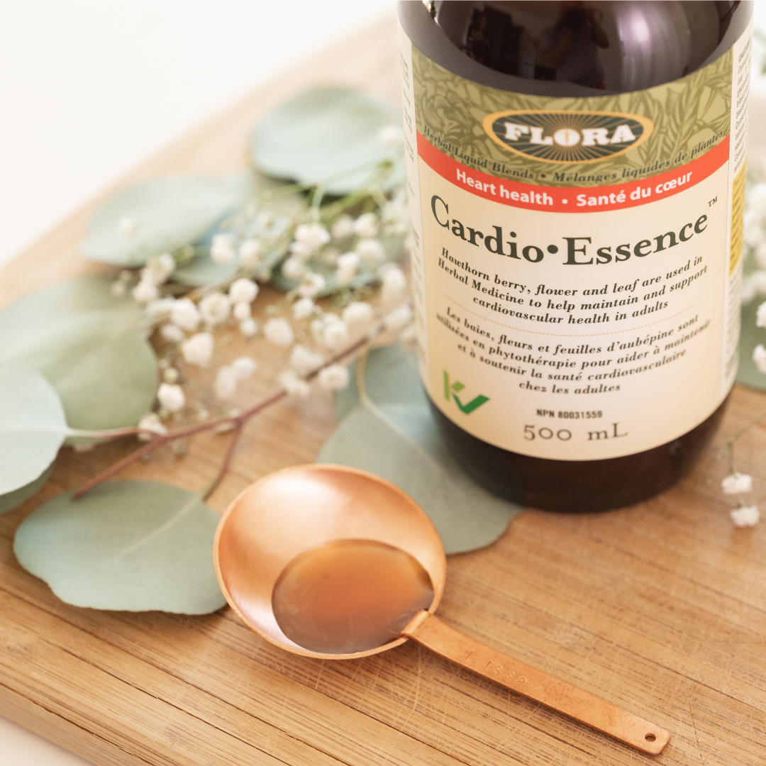 liquid heart supplement in copper spoon and 500ml Cardio Essence bottle by Flora pictured with hawthorn flowers and leaves